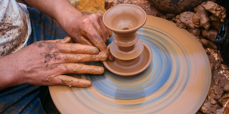 Artisan hands shaping clay on a pottery wheel